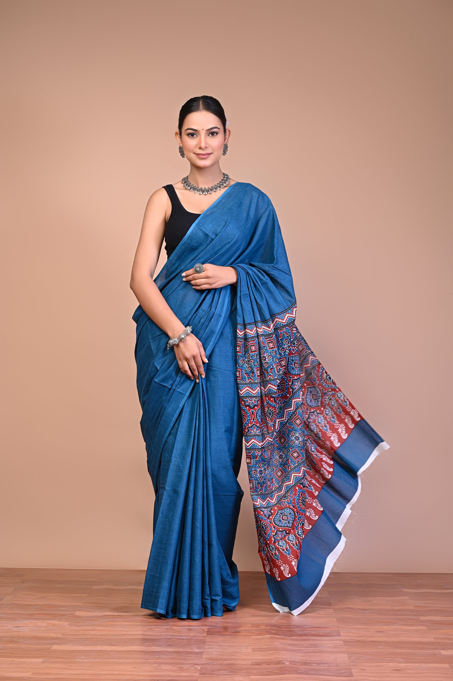 Elegant Blue Ajrakh Print Cotton Mul Saree draped elegantly on a model, showcasing vibrant patterns and rich textures.