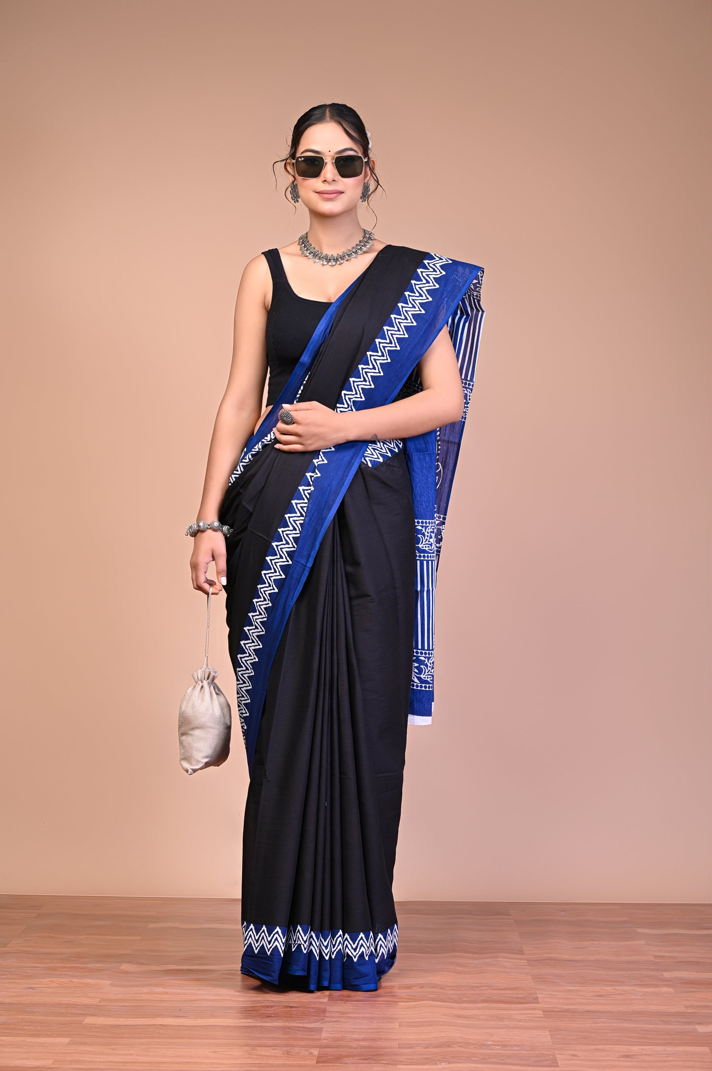 Elegant Black Blue Zigzag Border Cotton Mul Saree modeled by a woman, demonstrating grace and style.