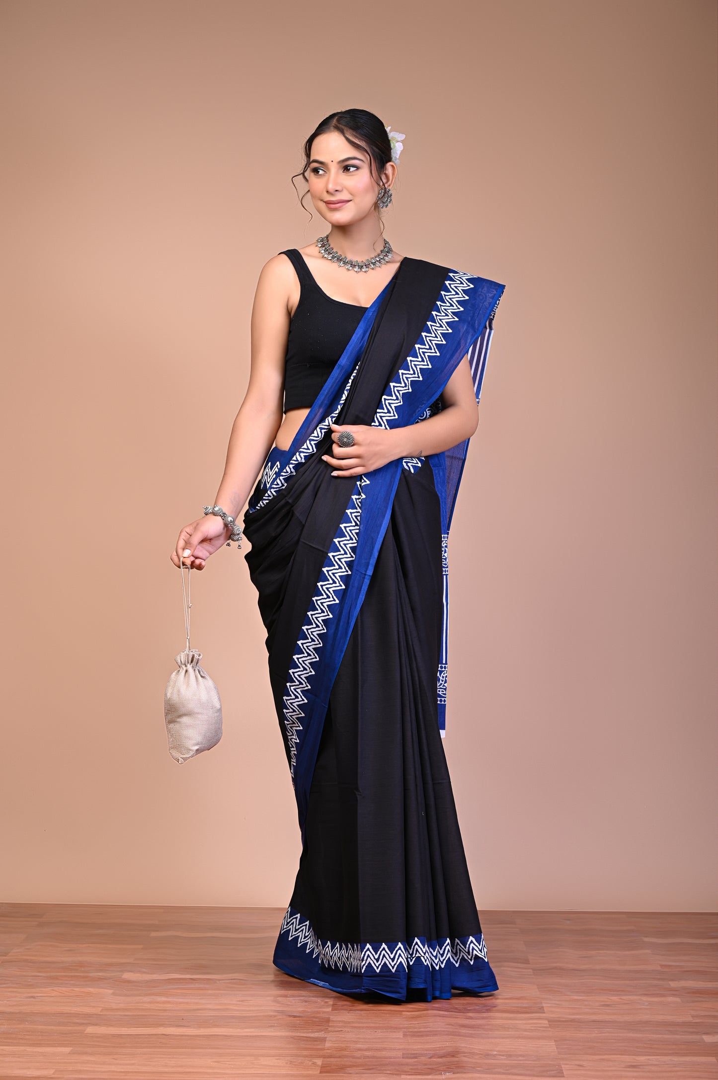 Elegant Black Blue Zigzag Border Cotton Mul Saree worn by a model with floral and geometric motifs.