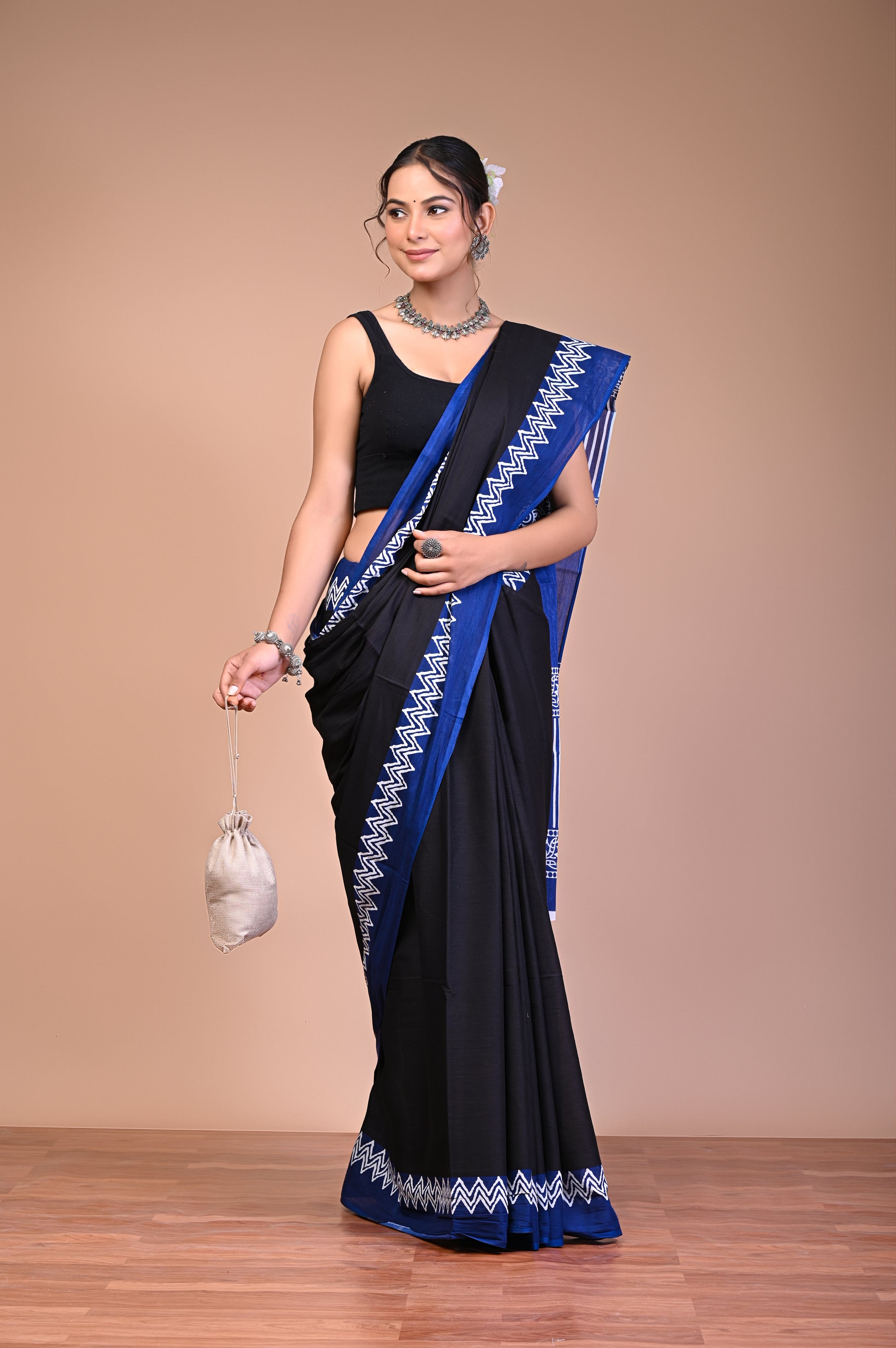 Elegant Black Blue Zigzag Border Cotton Mul Saree worn by a model with floral and geometric motifs.