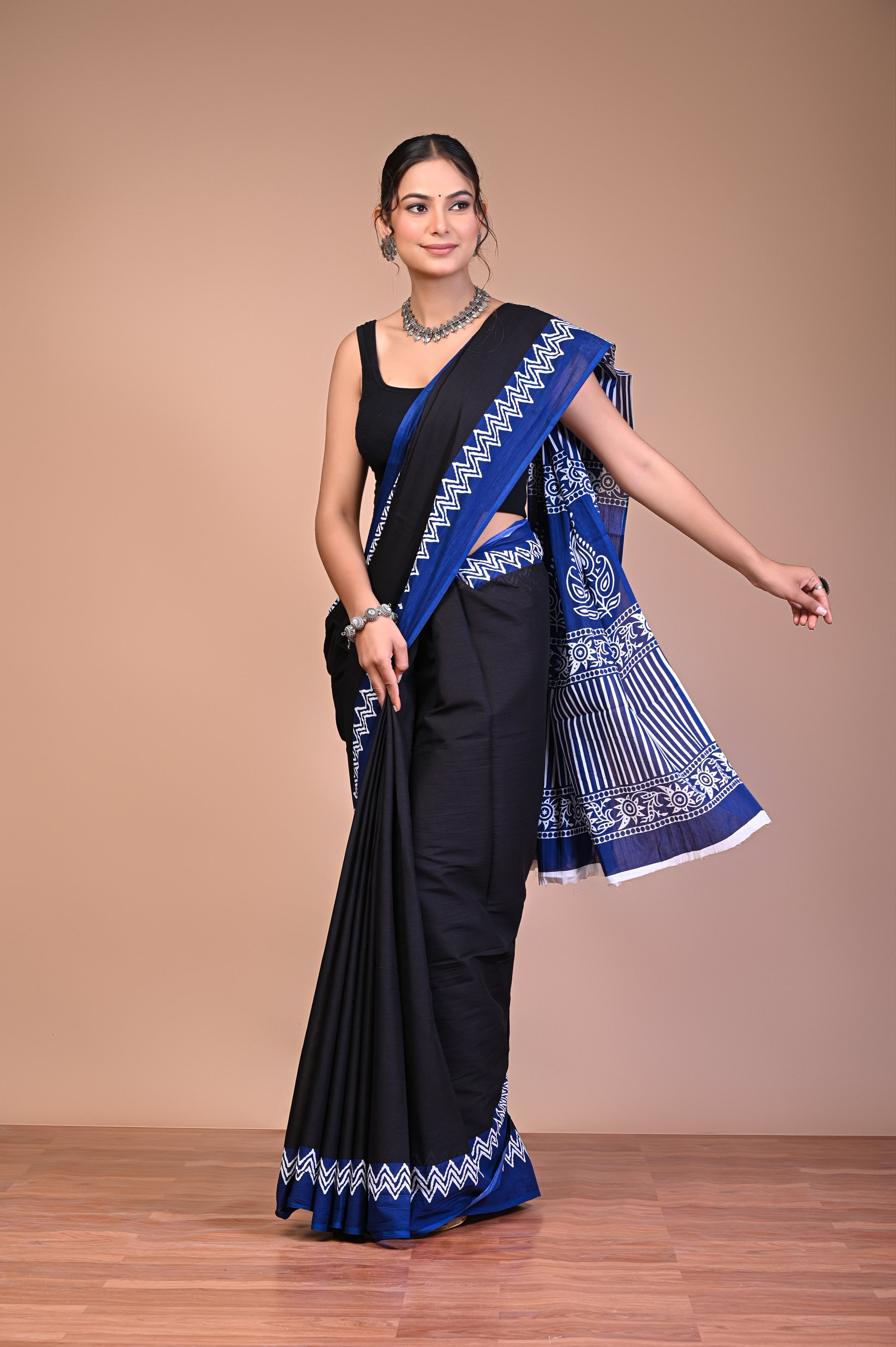 Elegant Black Blue Zigzag Border Cotton Mul Saree worn elegantly by a model showcasing its intricate design and traditional charm.