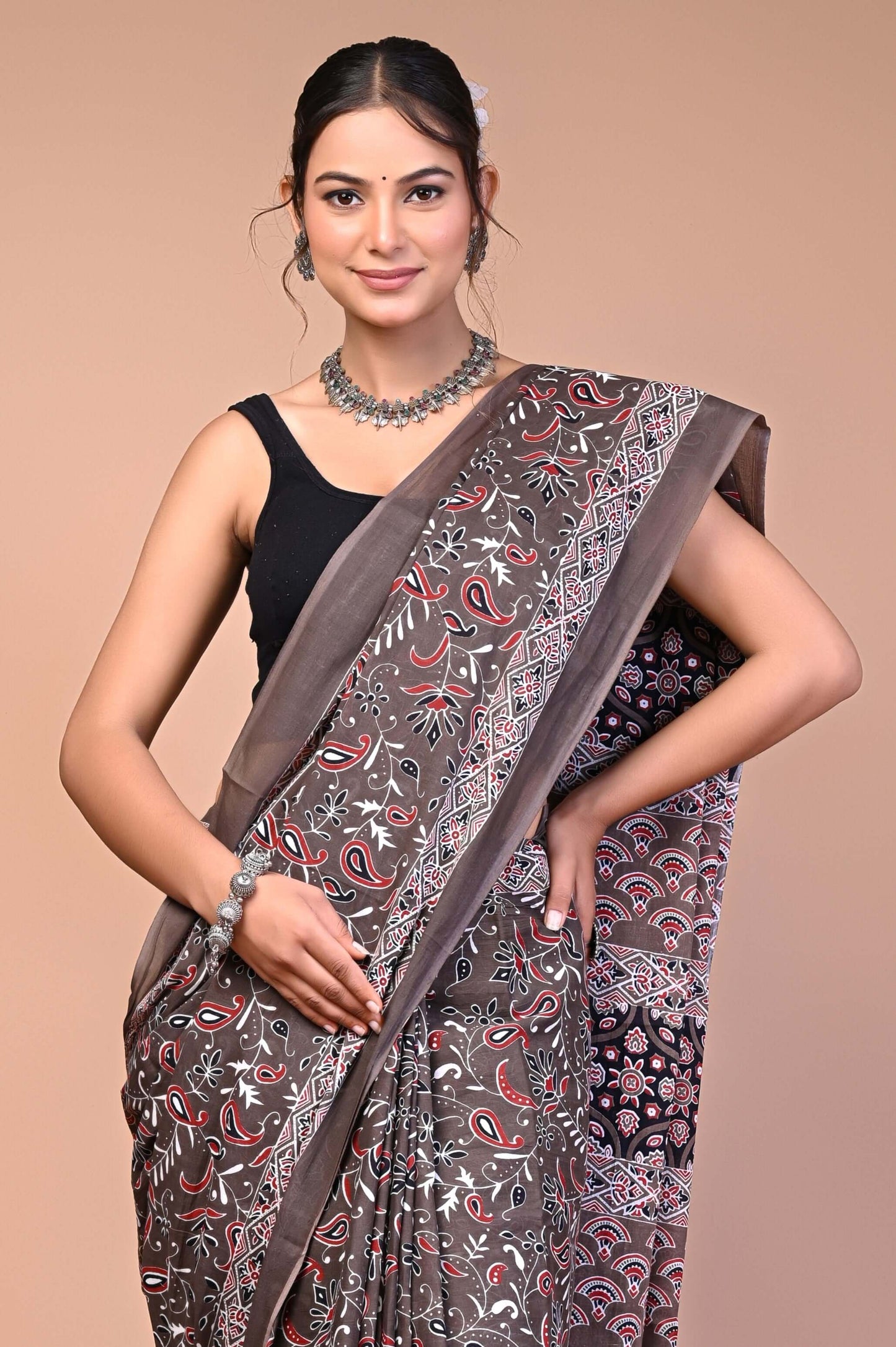 Elegant Brown Ajrakh Printed Cotton Mul Saree worn by a model showcasing its intricate design and elegant style.