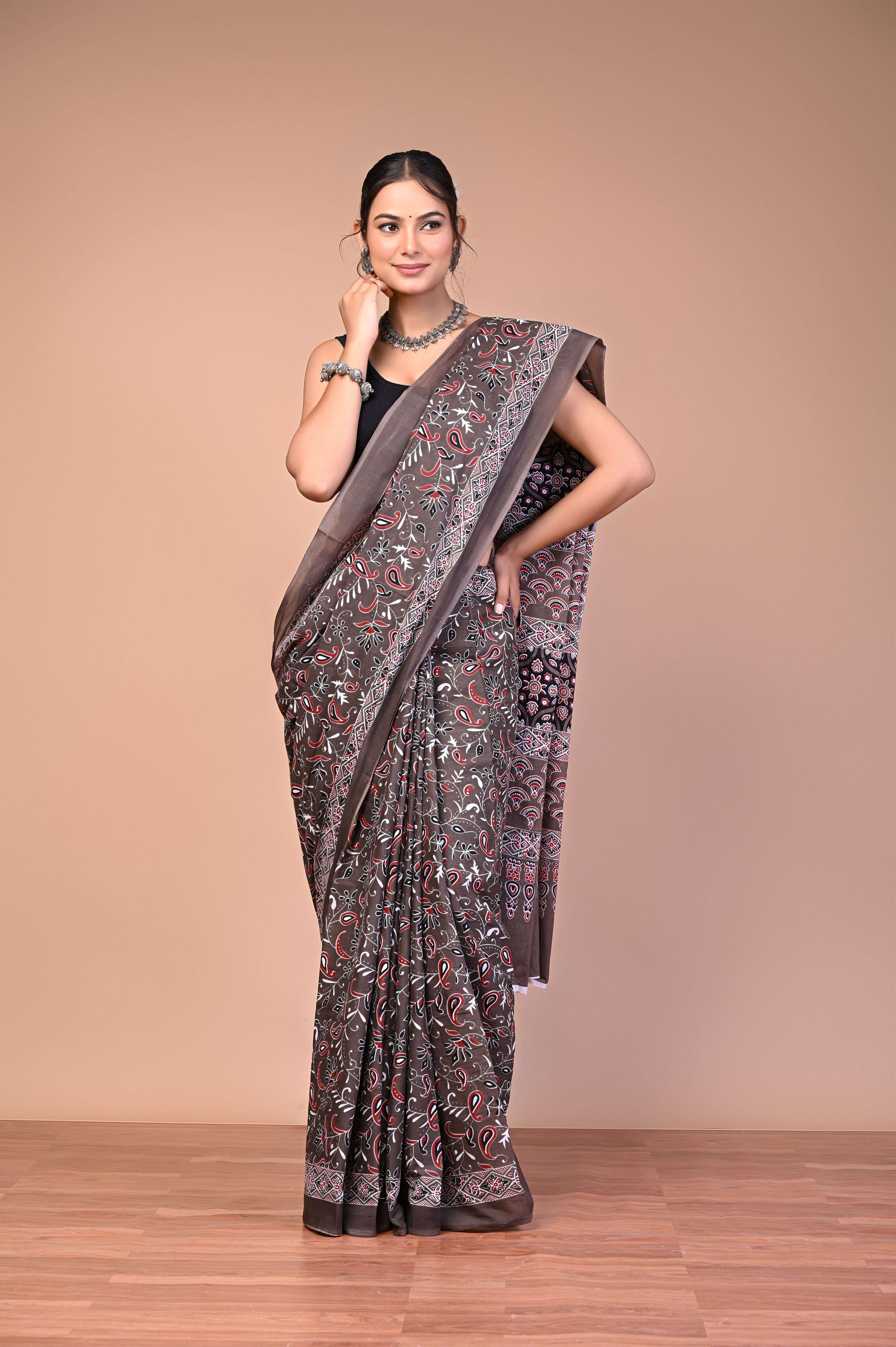 Elegant Brown Ajrakh Printed Cotton Mul Saree worn by a woman, showcasing traditional design and modern elegance.